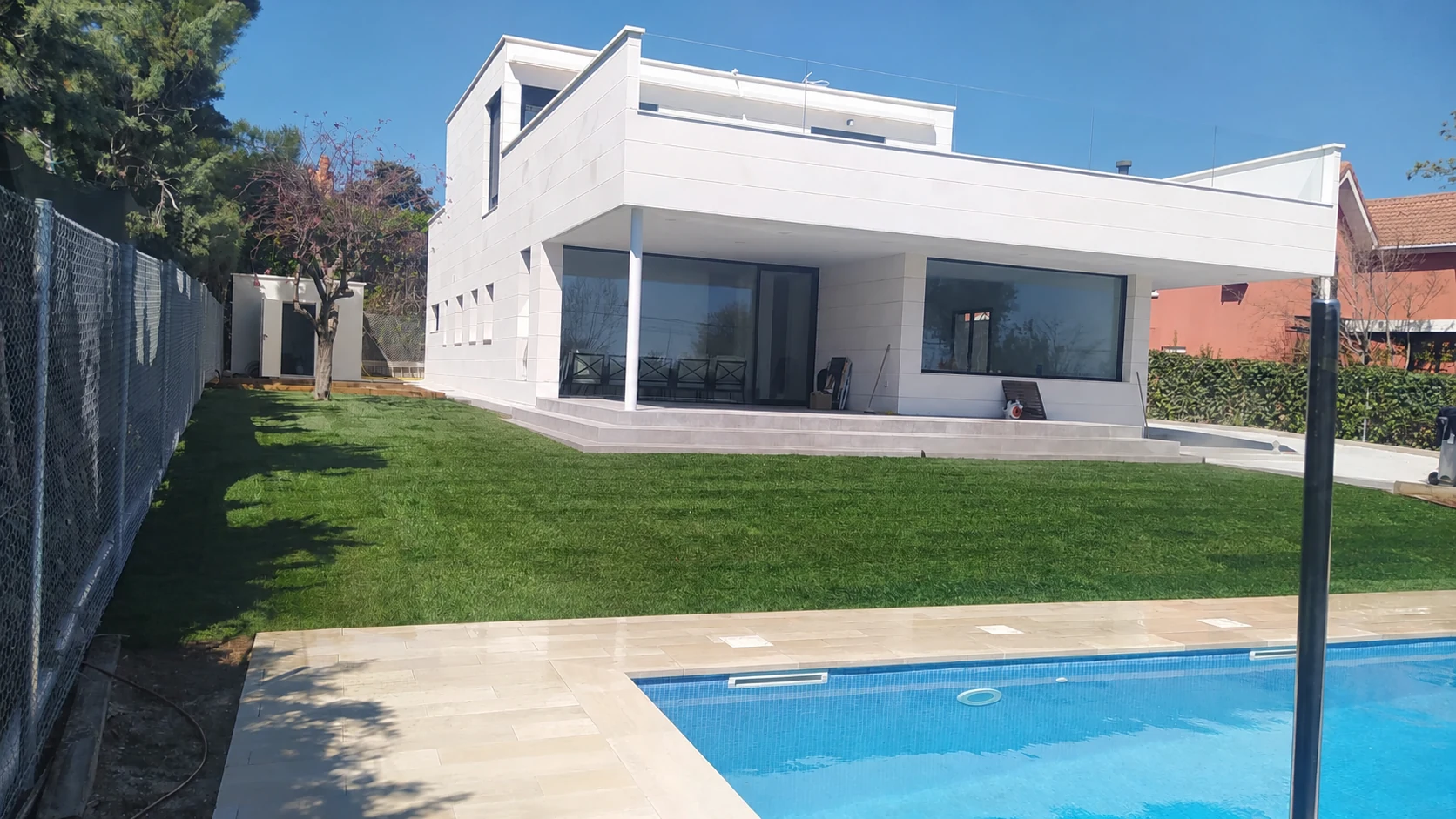Vista panorámica de la piscina y la pradera de césped natural terminada
